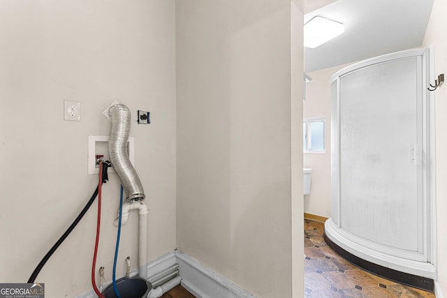 bathroom with stone finish flooring and a stall shower