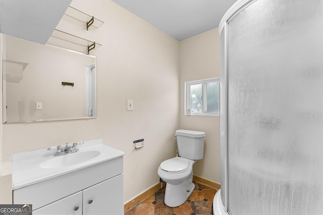 full bathroom featuring baseboards, vanity, a shower stall, and toilet