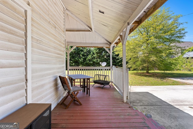 wooden deck featuring a lawn