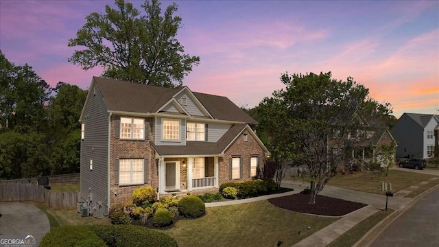 view of front of property with fence, central AC, and brick siding