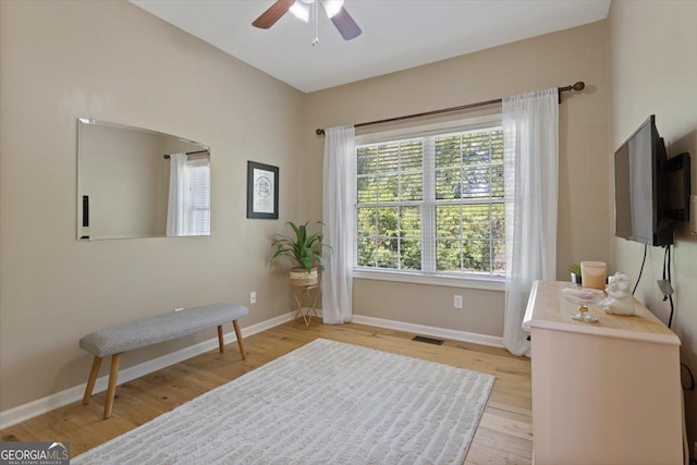 living area with a healthy amount of sunlight, baseboards, a ceiling fan, and visible vents