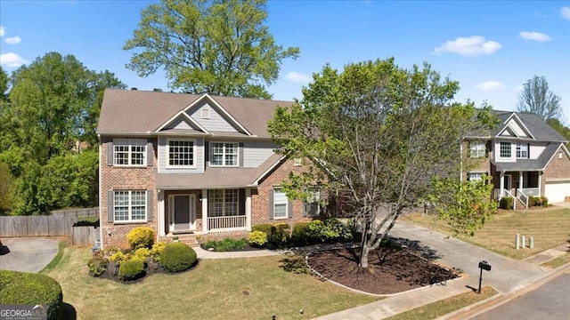 view of front of house featuring fence, a front lawn, and brick siding