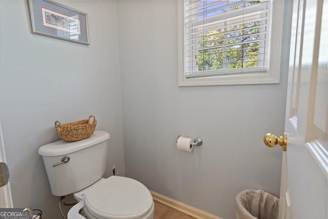 bathroom with toilet and baseboards