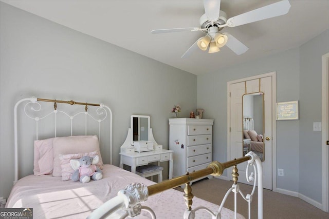 carpeted bedroom featuring baseboards and ceiling fan