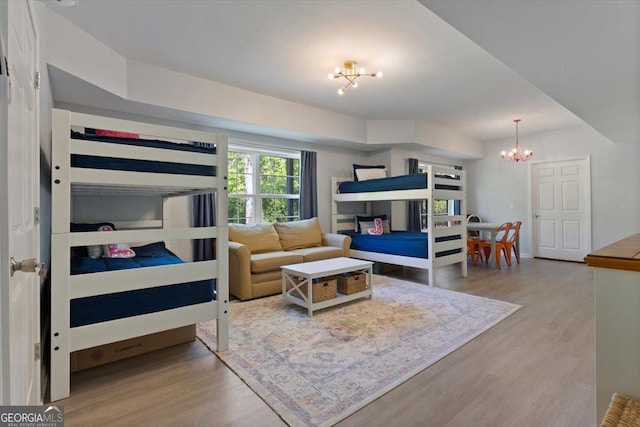 bedroom with wood finished floors and a notable chandelier