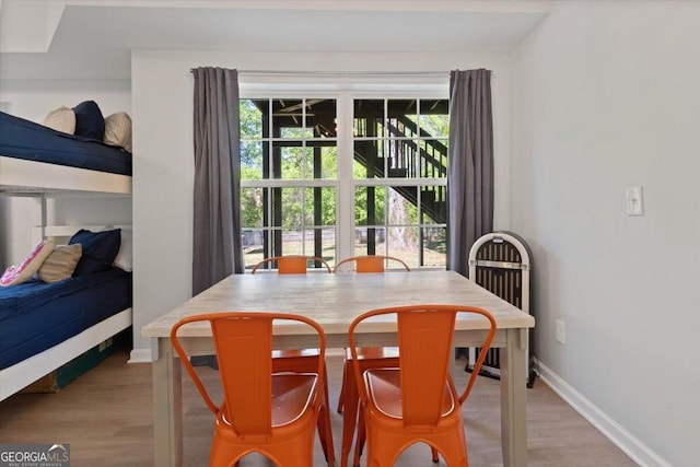 dining area featuring baseboards, a healthy amount of sunlight, and wood finished floors