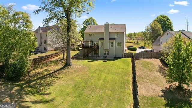 rear view of property featuring stairs, a fenced backyard, a wooden deck, and a yard