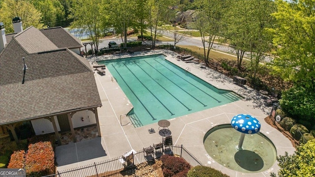 community pool with a patio and fence