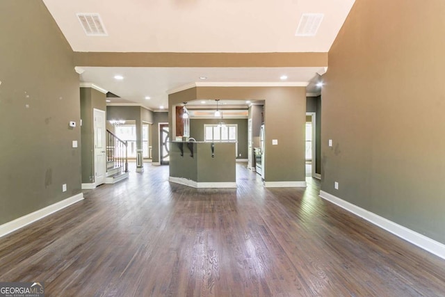 100 Hickory Dr, Stockbridge, GA 30281 - unfurnished living room featuring dark wood-style flooring, visible vents, baseboards, and ornamental molding