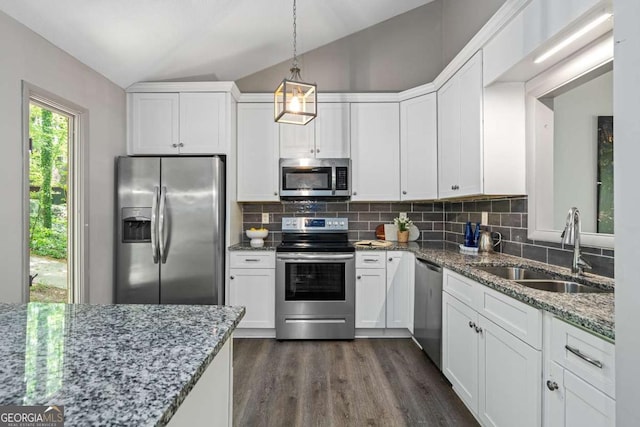 kitchen with lofted ceiling, white cabinets, a sink, and appliances with stainless steel finishes