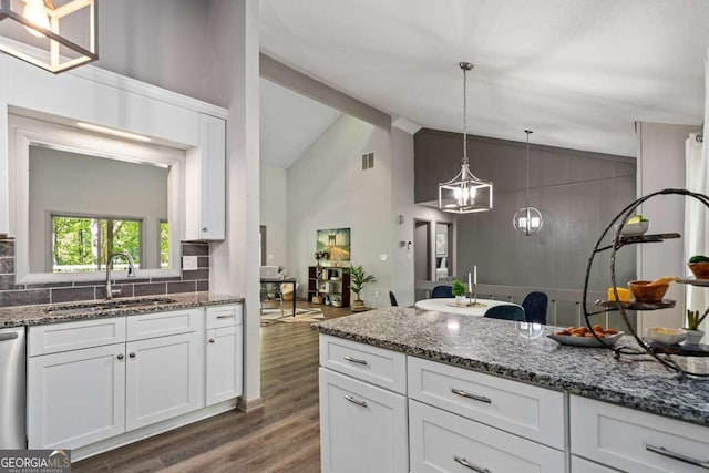 kitchen featuring visible vents, a sink, dark wood-type flooring, stone counters, and white cabinetry