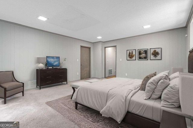 carpeted bedroom with visible vents, a textured ceiling, and ornamental molding