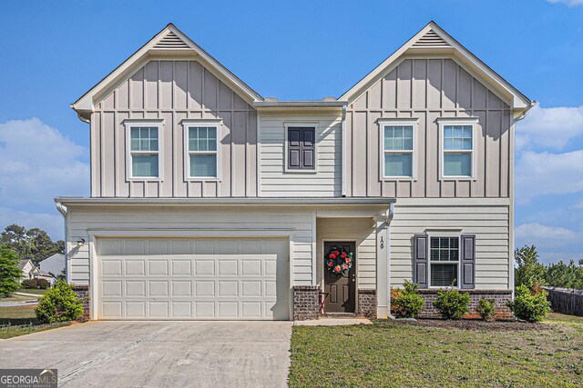 129 Coldwater Way, Griffin, GA 30224 - view of front of home with board and batten siding, a garage, driveway, and a front lawn