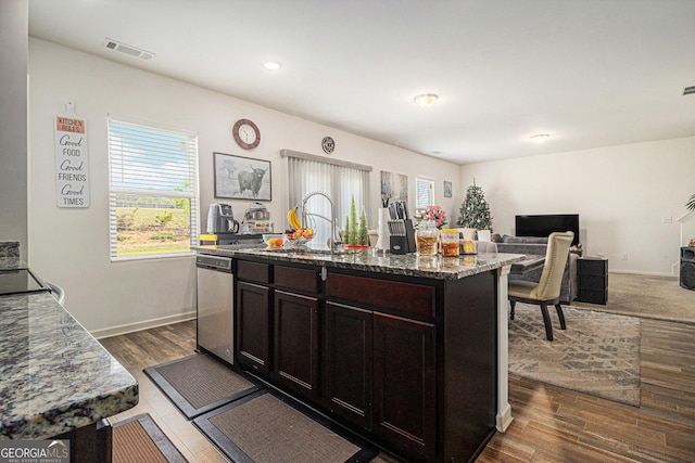 129 Coldwater Way, Griffin, GA 30224 - kitchen featuring dishwasher, a sink, dark wood-style floors, open floor plan, and dark stone counters
