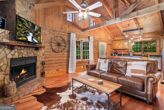 living area featuring high vaulted ceiling, wood finished floors, ceiling fan, beamed ceiling, and wooden ceiling