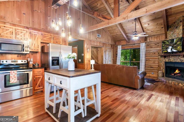 kitchen with stainless steel appliances, light wood-type flooring, wood ceiling, wood counters, and open floor plan