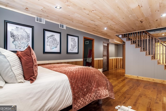bedroom with hardwood / wood-style flooring, wooden ceiling, baseboards, and visible vents
