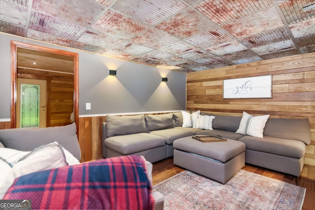 cinema room featuring wood walls and wood finished floors