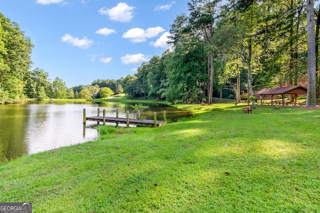 dock area with a lawn, a forest view, a gazebo, and a water view