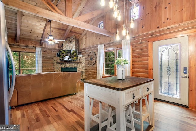 dining room with beamed ceiling, light wood-type flooring, wood ceiling, and high vaulted ceiling