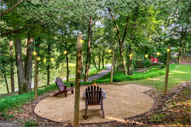view of home's community with a fire pit and a lawn