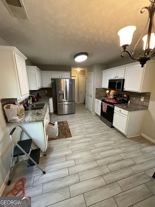 1086 Deshon Trl, Lithonia, GA 30058 - kitchen featuring stainless steel appliances, a sink, baseboards, tasteful backsplash, and a textured ceiling