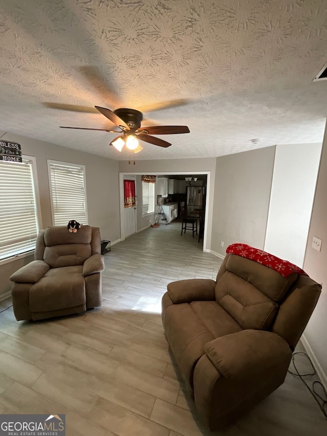 1086 Deshon Trl, Lithonia, GA 30058 - living room featuring baseboards, a ceiling fan, and a textured ceiling
