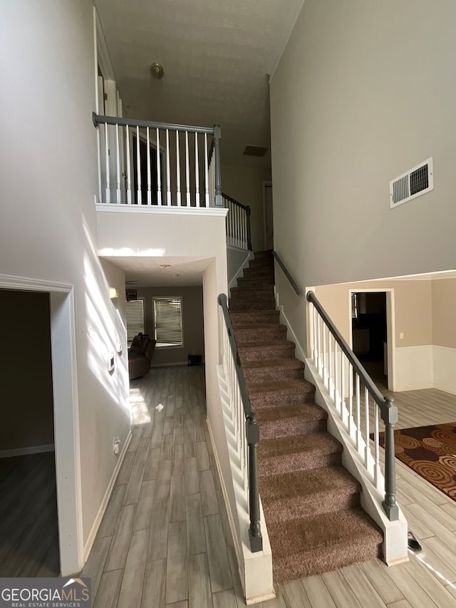 1086 Deshon Trl, Lithonia, GA 30058 - stairs with wood finished floors, a towering ceiling, and baseboards
