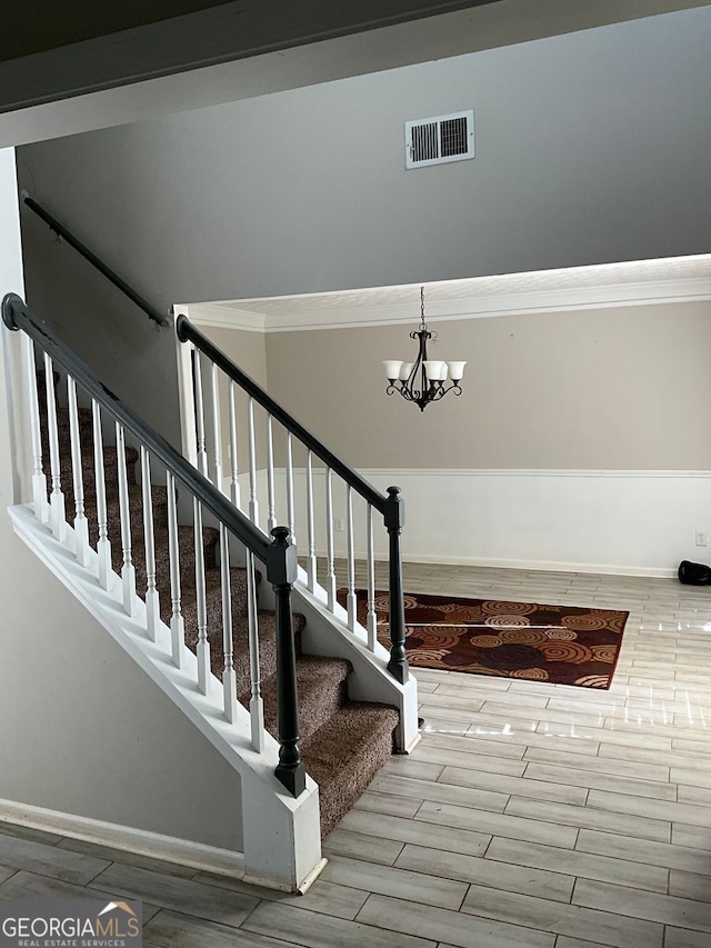 1086 Deshon Trl, Lithonia, GA 30058 - stairway with baseboards, a chandelier, ornamental molding, and wood finished floors