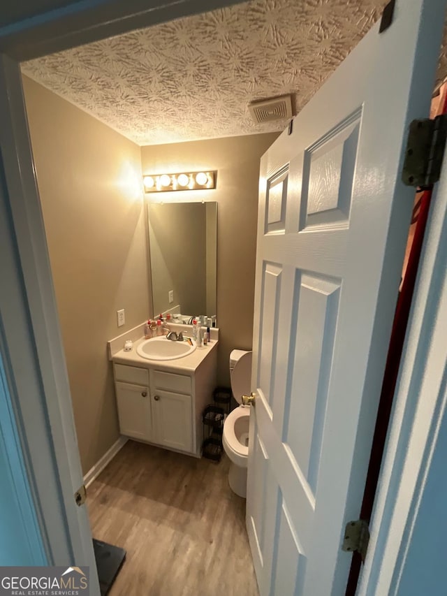 1086 Deshon Trl, Lithonia, GA 30058 - half bathroom featuring wood finished floors, vanity, and toilet