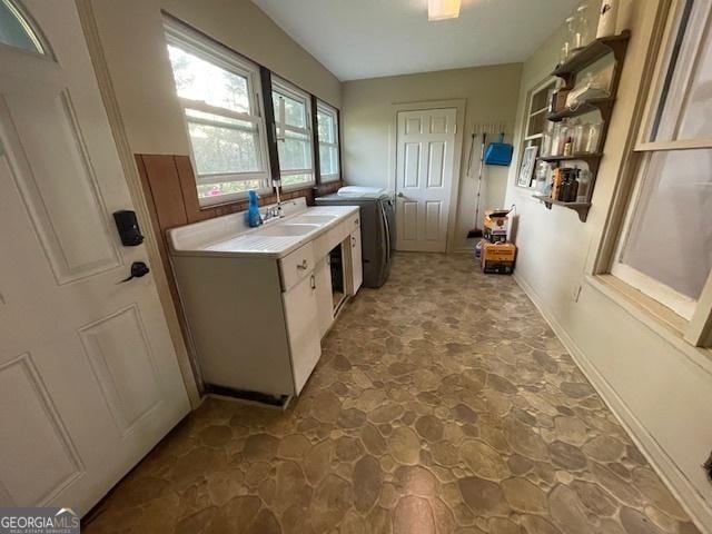 7650 Neese Commerce Rd, Hull, GA 30646 - kitchen featuring stone floors, light countertops, washer and dryer, open shelves, and a sink