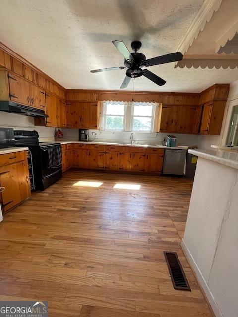 7650 Neese Commerce Rd, Hull, GA 30646 - kitchen with black electric range oven, brown cabinets, and under cabinet range hood