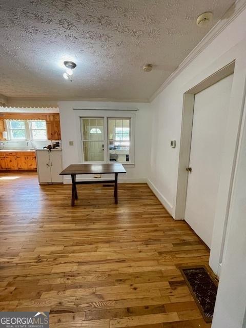 7650 Neese Commerce Rd, Hull, GA 30646 - dining room featuring a textured ceiling, light wood-style floors, ornamental molding, plenty of natural light, and baseboards