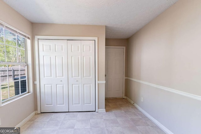 805 Old Rocky Rd, Atlanta, GA 30349 - unfurnished bedroom with baseboards, a textured ceiling, and a closet