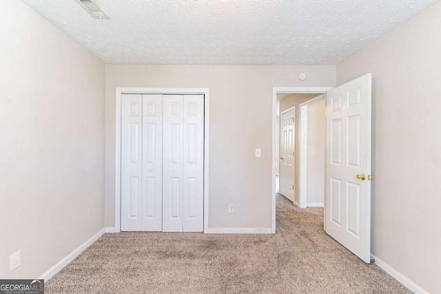 805 Old Rocky Rd, Atlanta, GA 30349 - unfurnished bedroom with baseboards, a textured ceiling, and carpet