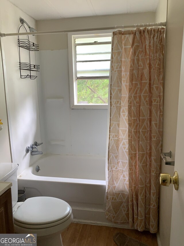 339 Gwenda St, Adrian, GA 31002 - bathroom with vanity, toilet, wood finished floors, and shower / tub combo with curtain