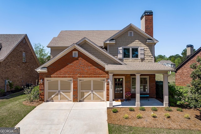 view of front of home featuring a garage, a chimney, brick siding, a porch, and driveway