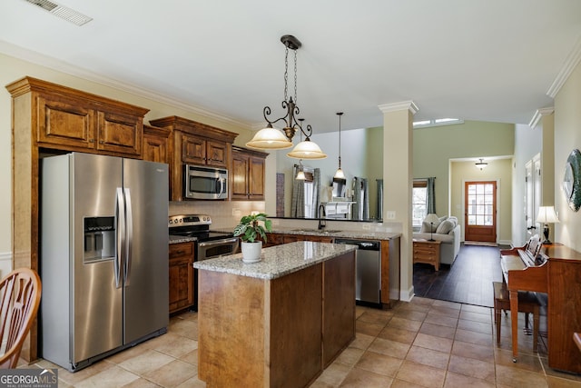 kitchen with light stone counters, appliances with stainless steel finishes, a sink, a center island, and visible vents