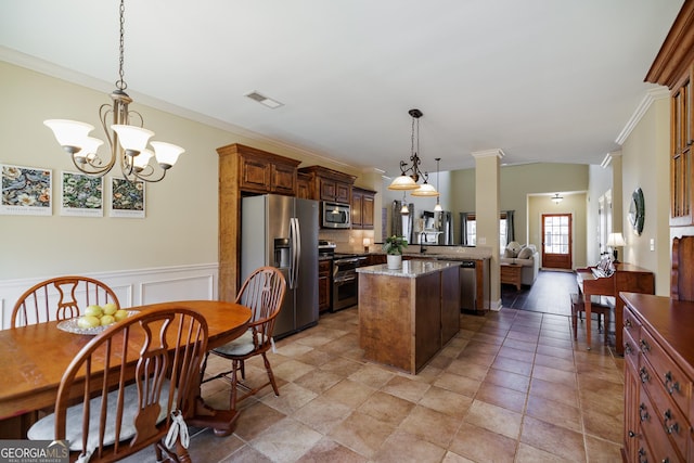 kitchen featuring crown molding, hanging light fixtures, appliances with stainless steel finishes, a center island, and visible vents