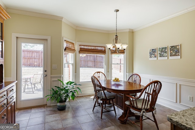 dining room with an inviting chandelier, plenty of natural light, and a decorative wall