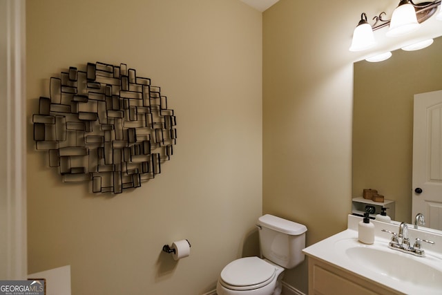 half bath featuring vanity and toilet