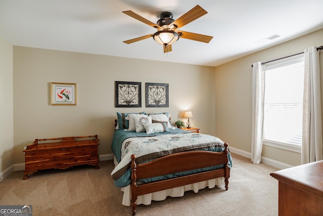 bedroom with baseboards, a ceiling fan, visible vents, and light carpet