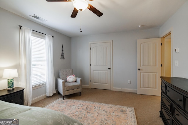 bedroom featuring visible vents, a ceiling fan, baseboards, and light colored carpet