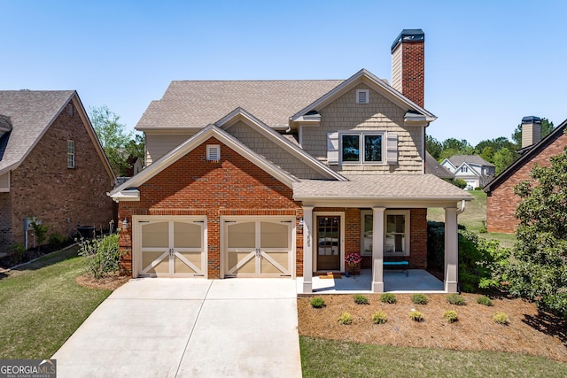 view of front of home featuring a garage, a front yard, a chimney, concrete driveway, and a porch
