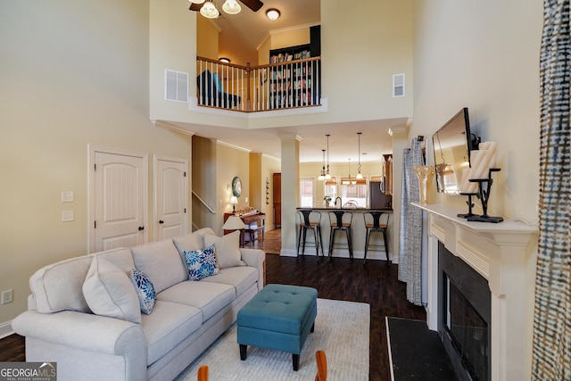 living room featuring baseboards, visible vents, and dark wood-style floors