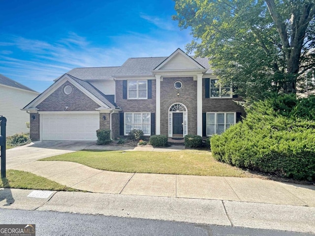 view of front of home with a front lawn, driveway, brick siding, and a garage