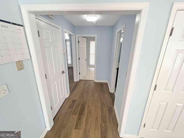 hallway with baseboards and dark wood finished floors