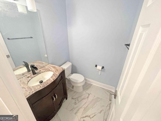bathroom featuring baseboards, marble finish floor, vanity, and toilet