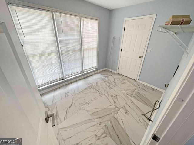 interior space featuring marble finish floor and baseboards
