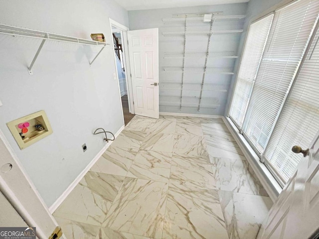 laundry room featuring washer hookup, marble finish floor, and baseboards